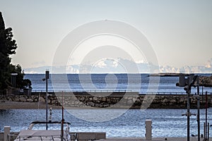 Italian Alps, visible across the sea from the croatian side of the coast at the town of Rovinj, during cold, winter sunset