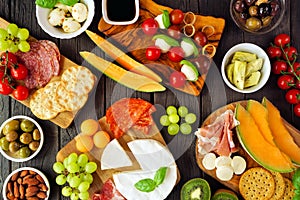 Italian antipasti table scene against a dark wood background. Above view.