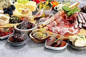 Italian antipasti wine snacks set. Cheese variety, Mediterranean olives, crudo, Prosciutto di Parma, salami and wine in glasses