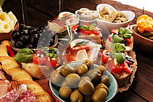 Italian antipasti wine snacks set. Cheese variety, Mediterranean olives, pickles, Prosciutto di Parma, tomatoes, artichokes and