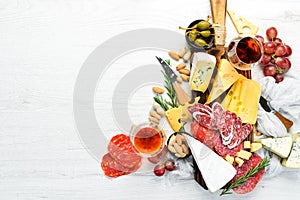 Italian antipasti wine snacks set. Cheese variety, salami and grapes on a white wooden background. Italian cuisine.