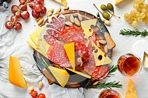 Italian antipasti wine snacks set. Cheese variety, salami and grapes on a white wooden background. Italian cuisine. Top view. Free