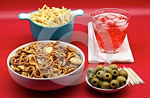 Italian aperitive: glass of frozen cocktail with green pitted olves, fries and salted pretzels snack for party