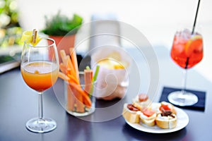 Italian aperitives/aperitif: two glasses of cocktail and appetizer platter on the table