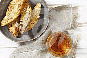 Italian biscotti cookies in grey plate and sweet wine Vin Santo. Fresh baked cookies with nuts
