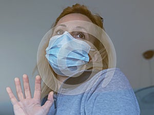 Italian blonde woman with protective mask forced to stay closed at home for the quarantine following the spread of the coronavirus