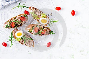 Italian bruschetta sandwiches with canned tuna, tomatoes and capers.