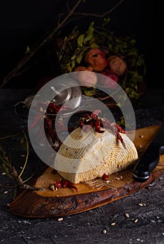 Italian caciotta cheese with hot chili pepper on rustic wooden cutting board