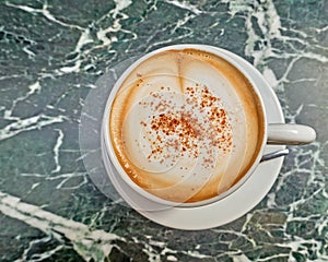 Italian caffelatte cup on green marble table