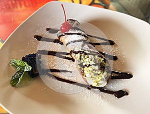 Italian Canoli Dessert with Chocolate Sauce and Cherry