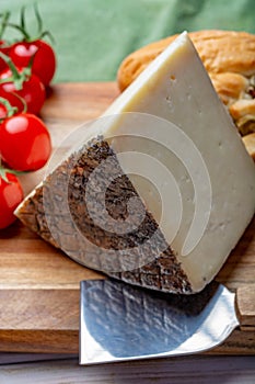 Italian cheese, piece of mature Tuscan Pecorino sheep cheese served with olive bread and tomatoes