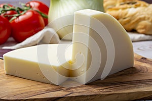 Italian cheese, Provolone dolce cow cheese from Cremona served with olive bread and tomatoes