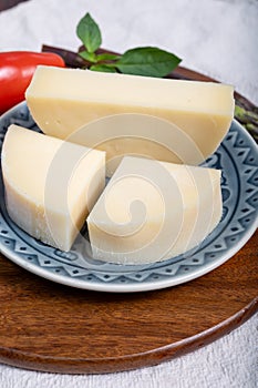 Italian cheese, Provolone dolce cow cheese from Cremona served with olive bread and tomatoes close up