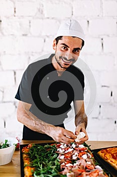 Italian chef pizzaiolo making pizza in restaurant kitchen