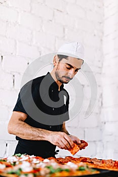 Italian chef pizzaiolo making pizza in restaurant kitchen