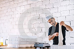 Italian chef pizzaiolo preparing pizza dough in restaurant kitchen