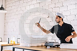 Italian chef pizzaiolo preparing pizza dough in restaurant kitchen