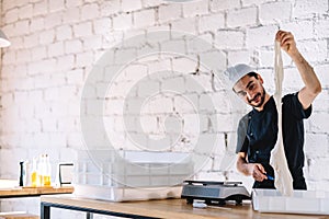 Italian chef pizzaiolo preparing pizza dough in restaurant kitchen