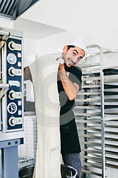 Italian chef pizzaiolo preparing pizza dough in restaurant kitchen