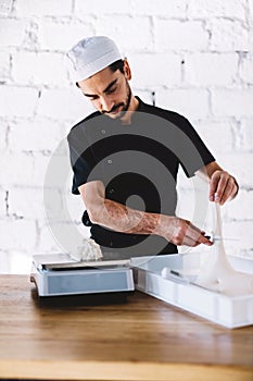 Italian chef pizzaiolo preparing pizza dough in restaurant kitchen