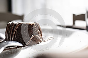 Italian chocolate dessert courant on a white plate and silver spoon