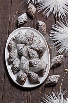 Italian Christmas cookies Castagnelle with almonds, cocoa and egg whites on a wooden background. Gluten free cookies.