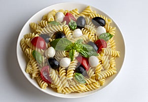 Italian cold pasta salad or Pasta fredda alla caprese. Directly above. Fusilli, tomato, mozzarella, olive, arugula. Turkish name