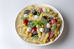 Italian cold pasta salad or Pasta fredda alla caprese. Fusilli, tomato, mozzarella, olive, arugula. Turkish name