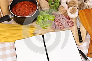 Italian cookbook or recipe book, ingredients for spaghetti bolognese, copy space