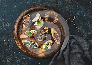 Italian crostini and glass of wine on round serving tray