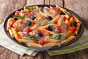Italian cuisine: pasta penne with meatballs, olives and tomatoes