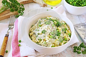 Italian cuisine. Plate of green pea risotto with green pea, parmesan cheese, olive oil and parsley