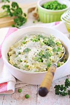 Italian cuisine. Plate of green pea risotto with parmesan cheese, olive oil and parsley