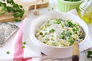 Italian cuisine. Plate of green pea risotto with green pea, parmesan cheese, olive oil and parsley