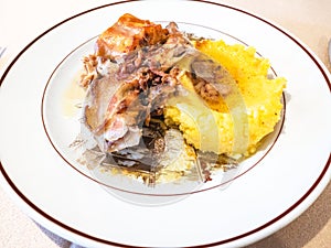 Italian cuisine - Rabbit with polenta on plate photo