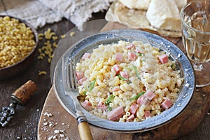 Italian Cuisine. Stortini pasta with fresh ham cubes, parmesan cheese and glass of white wine