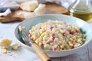 Italian Cuisine. Stortini pasta risotto with fresh ham cubes, grated parmesan cheese and olive oil