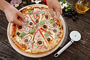 Italian cuisine. woman cooking and decorating delicious pizza