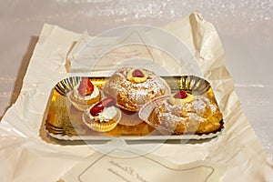 Italian dessert Zeppole di San Giuseppe, zeppola baked puffs made from choux pastry, filled and decorated with custard photo