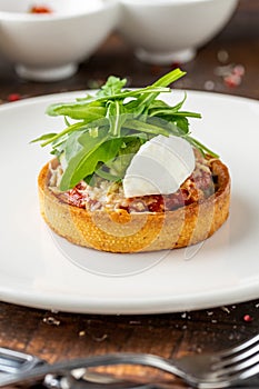 Italian dish Tortino di Verdure served on a white plate on wooden table