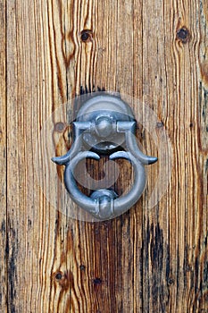 Italian door knocker on old wooden brown background