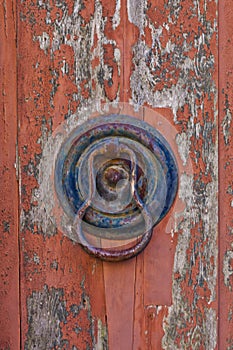 Italian door knocker on old wooden red background