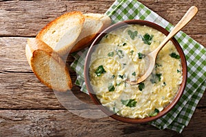 Italian egg soup stracciatella with farfalline pasta and parmesan close-up. horizontal top view