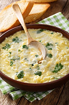 Italian egg soup stracciatella with farfalline pasta and parmesan close-up. vertical