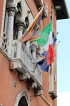 Italian and European flags waving on balcony in public square