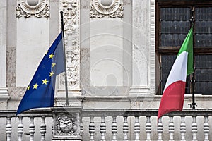 Italian and European flags waving on Italian building.