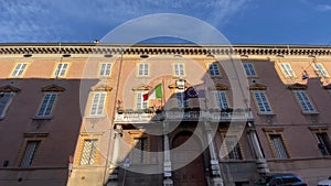 Italian and european flags waving in the wind on the balcony of government building.