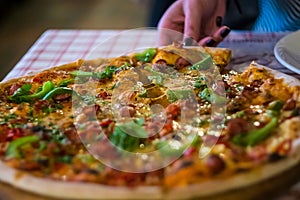 Italian fast food. Delicious  and appetizing hot pizza sliced and served on wooden platter with ingredients, close up view