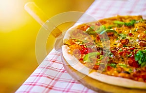 Italian fast food. Delicious  and appetizing hot pizza sliced and served on wooden platter with ingredients, close up view