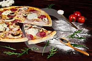 Italian fast food. Delicious hot pizza sliced and served on wooden platter with ingredients, close up view. Menu photo